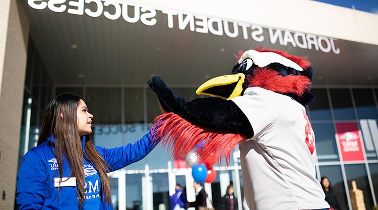 Rowdy high fives a Crew in Blue team member.